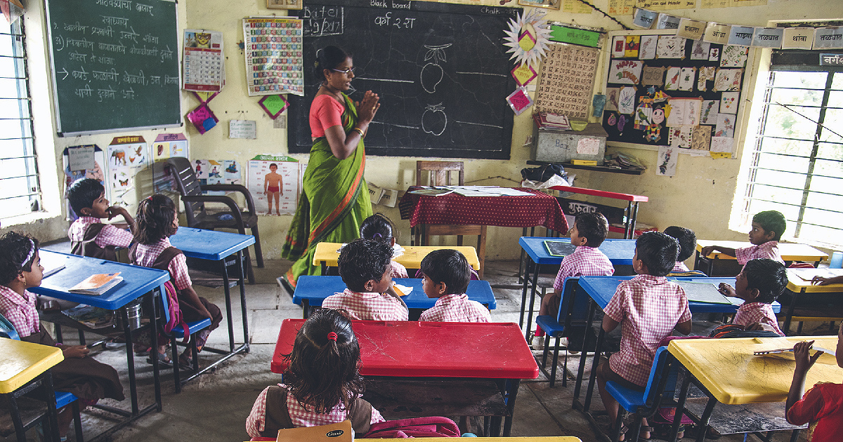 a person standing in front of a blackboard in a classroom