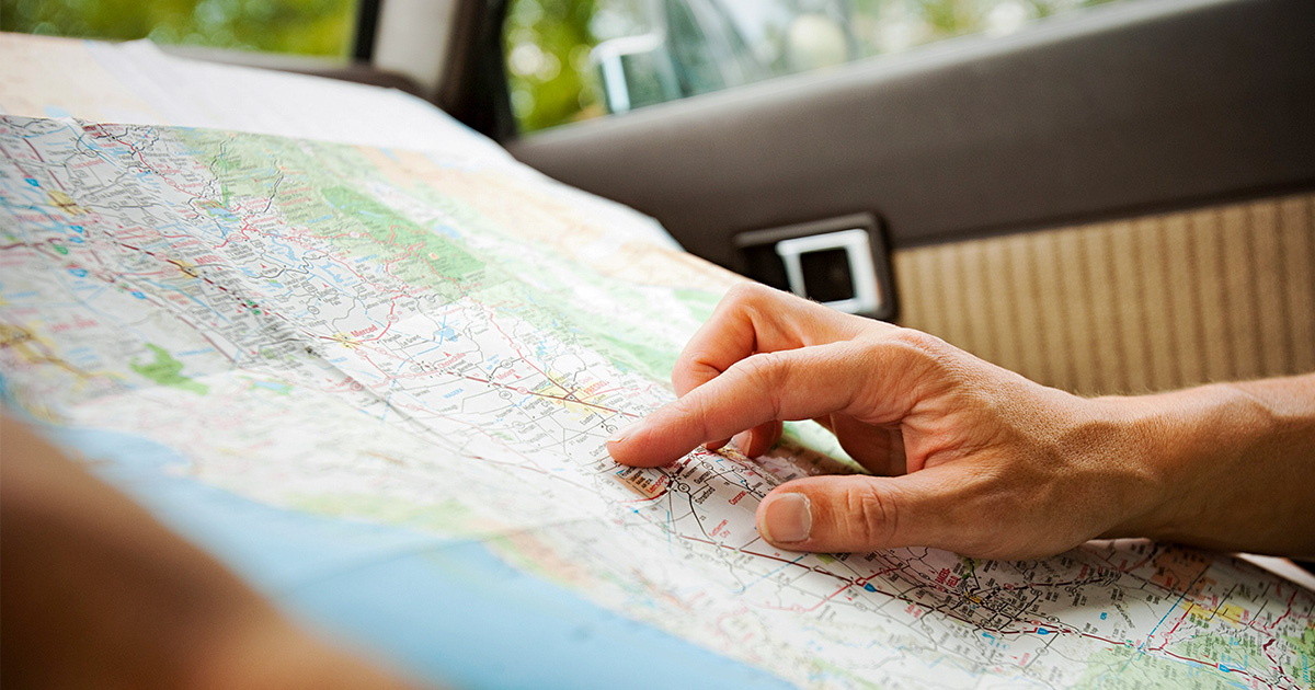 Image of hands holding a roadmap in a car