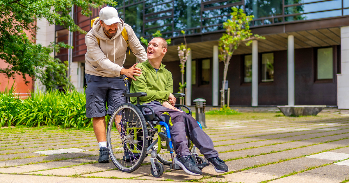 A group of older adults seated in a community room participate together in a guided stretching exercise.