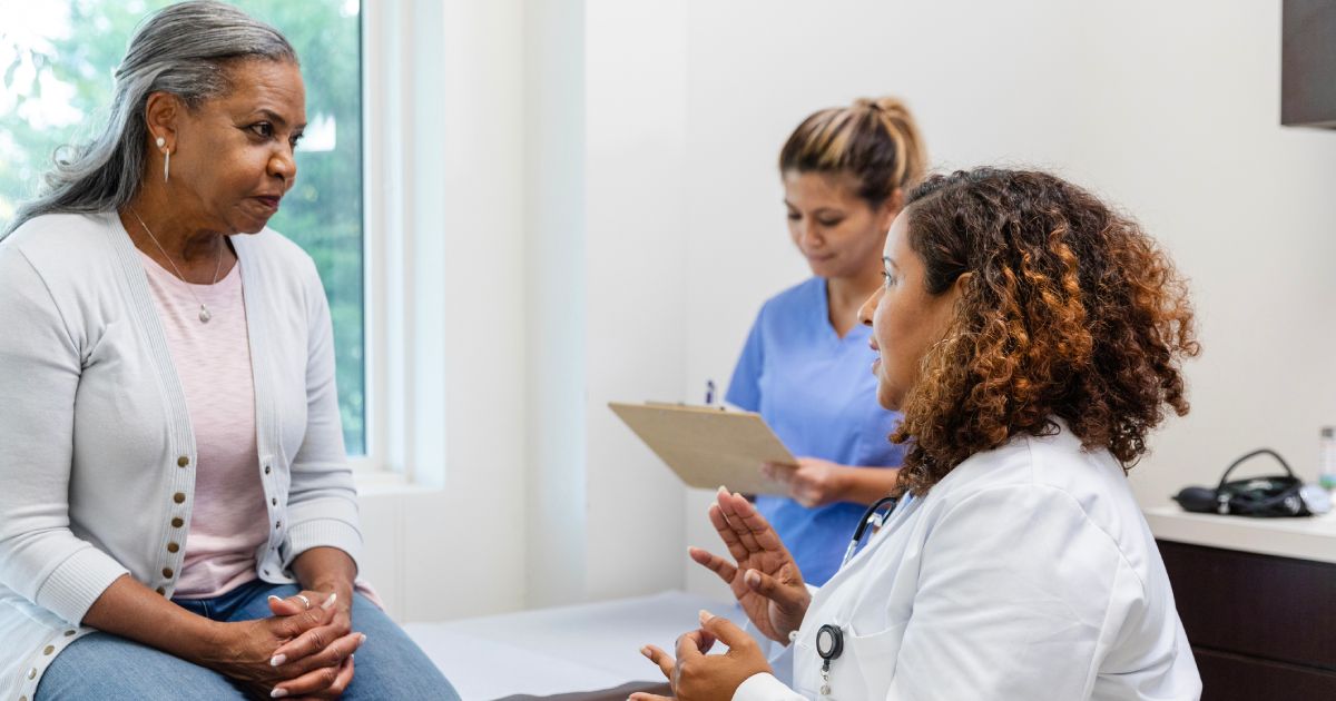 Serious senior woman listens to female doctor explain test results