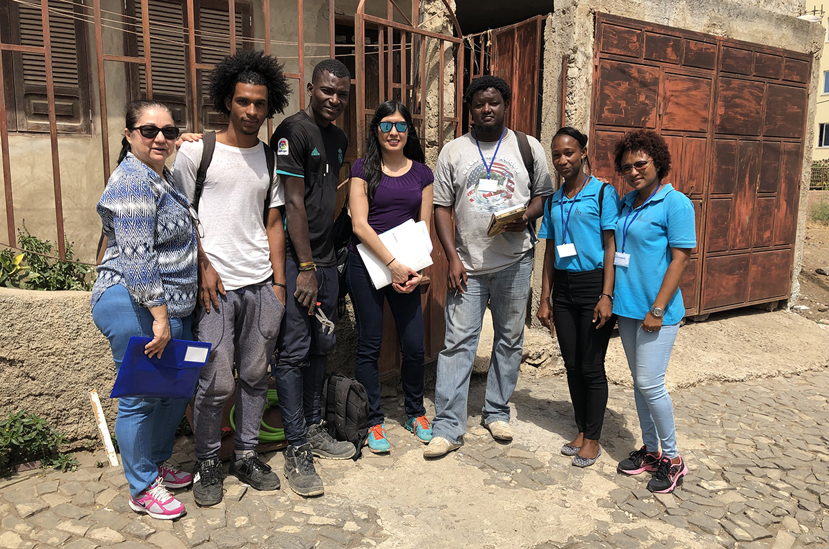 A group of people stand and smile at the camera. 