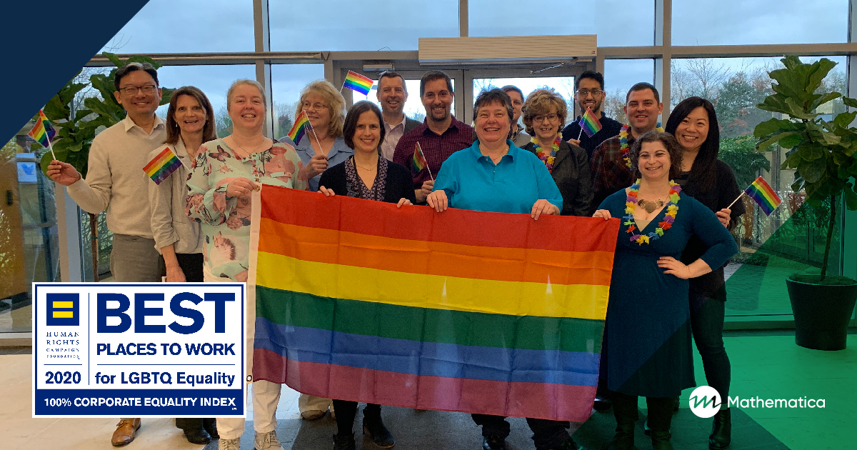 A group of staff smiles at the camera, posing with a rainbow flag. The HRC Best Places to Work for LGBTQ Equality 2020 logo is overlaid in a corner. 
