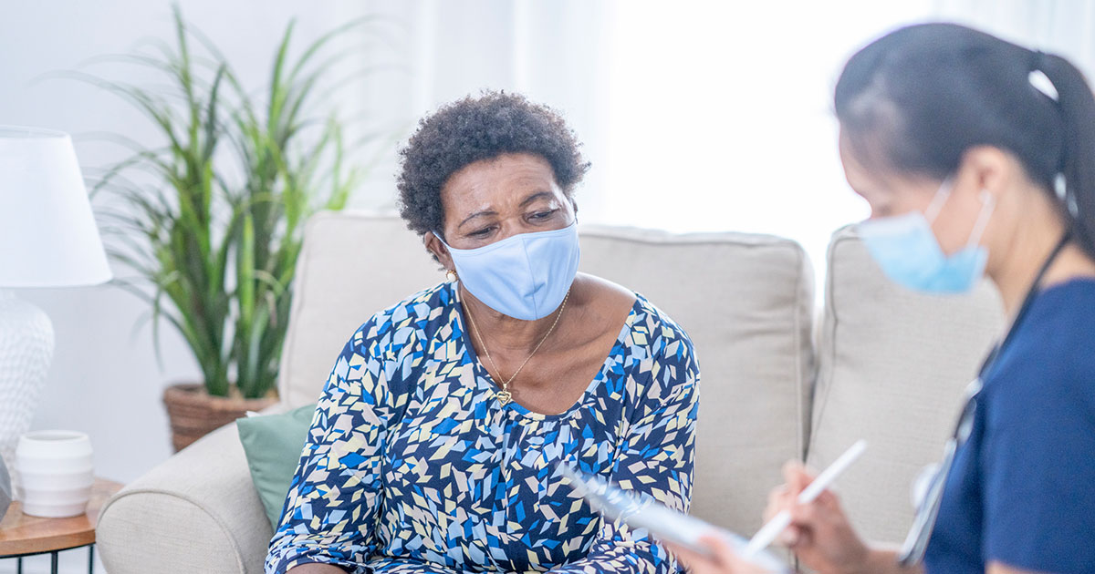 Nurse with patient taking information from her