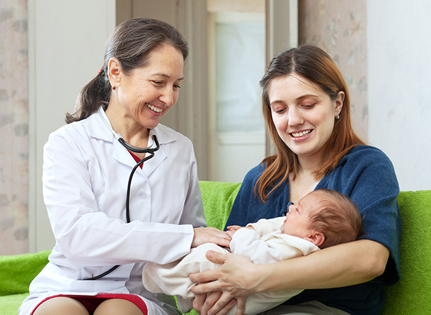 Doctor examining baby that mother is holding