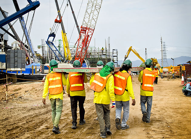 construction workers carrying beams
