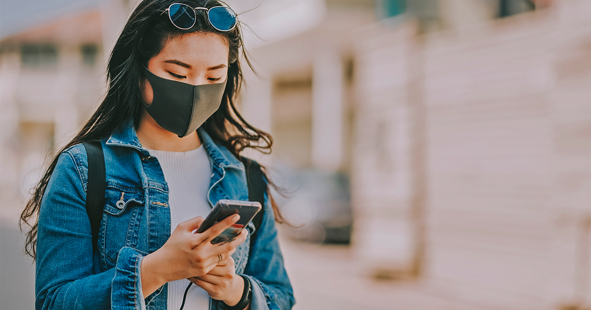 Girl wearing a mask looking at phone