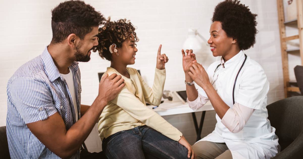 Therapist teaching father and deaf daughter sign language