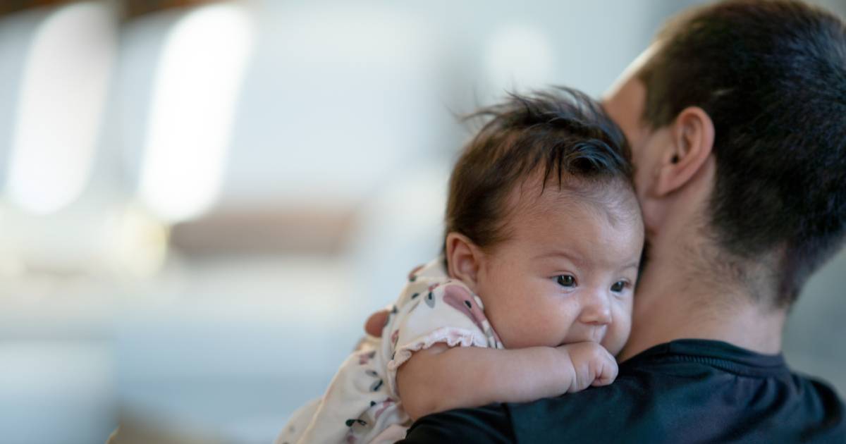 Native American father holding baby girl over his shoulder