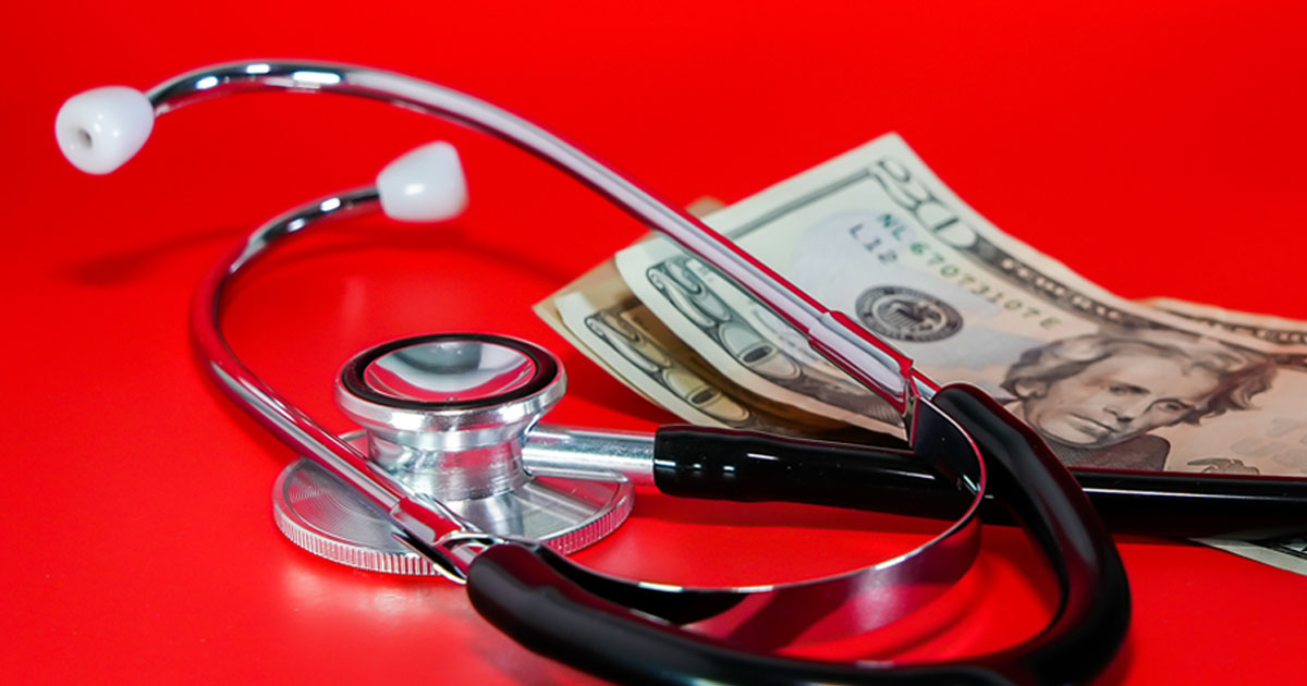 Stethoscope and money on red background