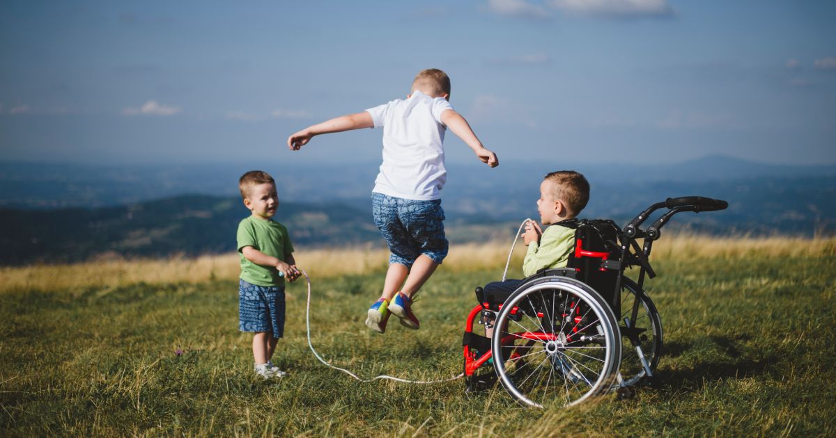 Little boy in wheelchair having activities with his brothers
