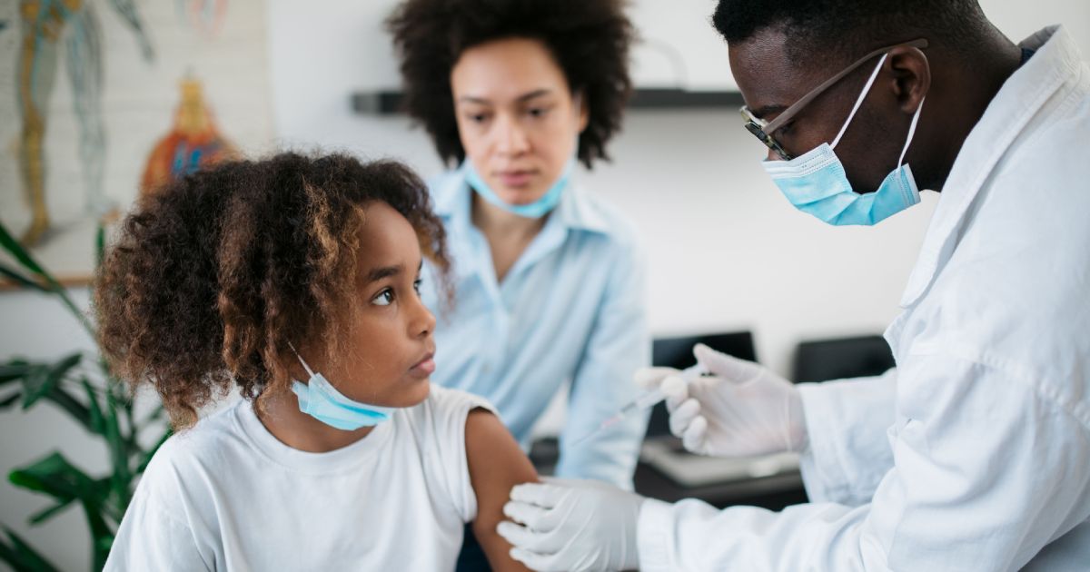 Young African American little girl taking a vaccine