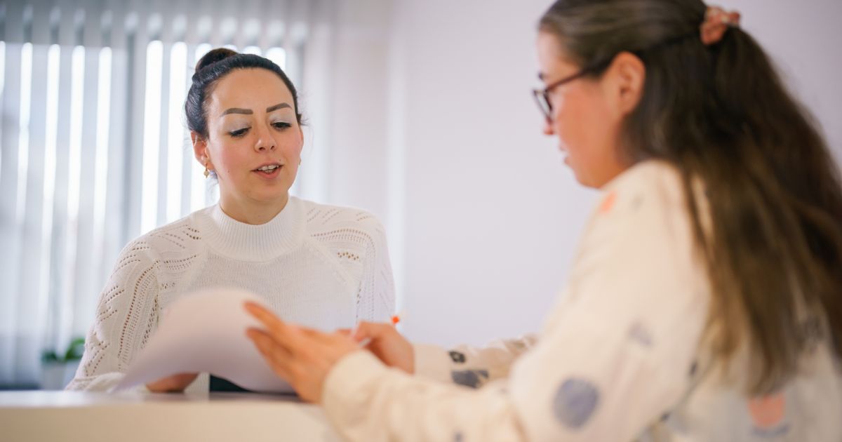 Female patient at the front desk, filling forms