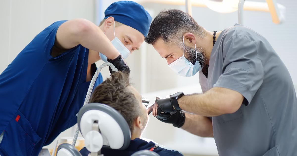 Surgeons during a dental operation. Anesthetized patient in the operating room. Installation of dental implants in the clinic