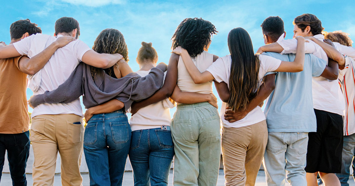 Group of students walking together on rooftop at sunset.