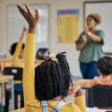 a person raising her hands in a classroom