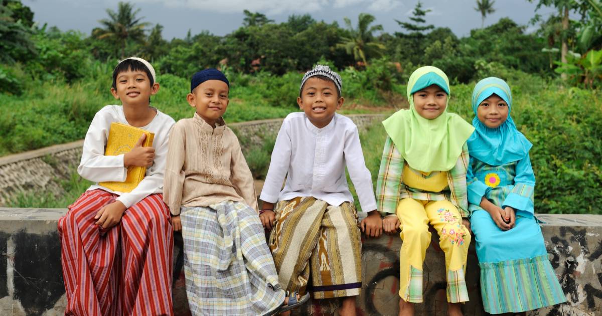 5 Indonesian children sitting on a wall